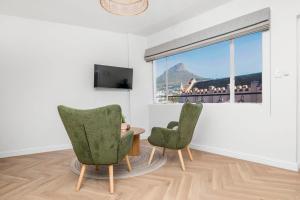 two chairs and a table in a room with a window at Flamingo on Hope in Cape Town