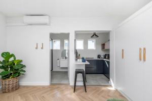 a kitchen with white walls and a stool in a room at Flamingo on Hope in Cape Town