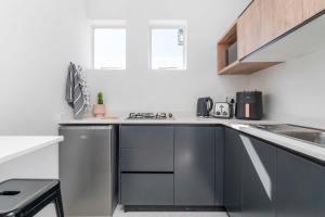 a kitchen with stainless steel cabinets and a sink at Flamingo on Hope in Cape Town