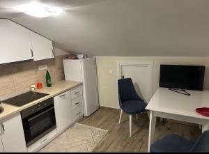 a small kitchen with a table and a refrigerator at Apartman Zelenika in Zelenika