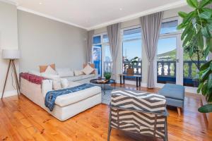 a living room with a white couch and some windows at Lovely Home in Trendy Bo-Kaap! in Cape Town
