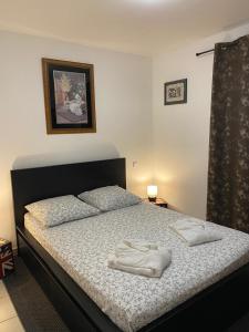 a bedroom with a bed with two towels on it at Agréable rez de jardin avec Piscine et Jacuzzi in Cervione +12 photos
