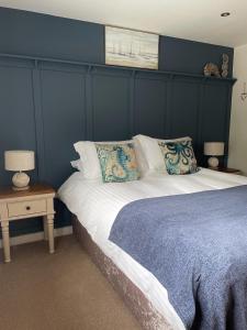 a bedroom with a large bed with a blue wall at Sunny Bank in Holsworthy