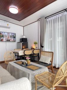a living room with a table and chairs at Anna River Home A1 in Ban Khlong Si