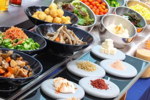 a buffet with plates of food and bowls of food at ART HOTEL Miyazaki Sky Tower in Miyazaki