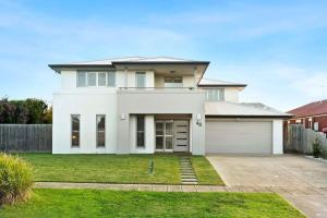 a white house with a garage at Seachange Family Escape with Pool and Spa Bath in Saint Leonards