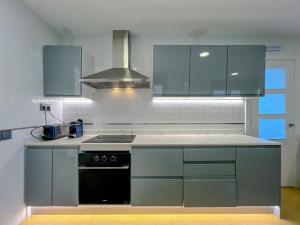 a kitchen with blue cabinets and a stove top oven at Vivalidays Dali - Costa Brava in Maçanet de la Selva