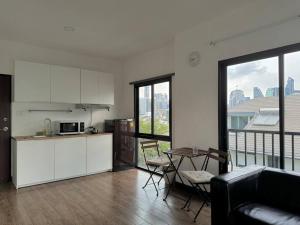una cucina con armadi bianchi e un tavolo con tavolo. di Skyline View 2 - BTS Thong Lo a Bangkok