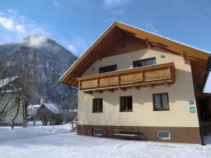 una casa nella neve con una montagna sullo sfondo di Haus Rye a Obertraun