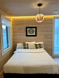 a bedroom with a bed and a chandelier at Arctic luxury log house with the river view in Rovaniemi