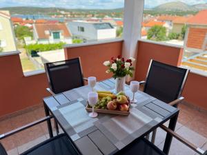 a table with a tray of fruit and a vase of flowers at Ferienhaus Bilice - Pool beheizt - Fitness - Relax in Bilice