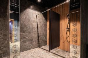 ein Badezimmer mit einer Dusche und einer Holztür in der Unterkunft Golden Apartments Zakopane - Mountain View in Zakopane + 108 Fotos