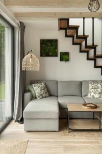 a living room with a couch and a staircase at Okno na Beskidy-domek LAS z balią , sauną i niesamowitym widokiem na góry in Maków Podhalański +49 photos