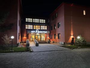 a building with a sign on the front of it at Marko Polo Hotel in Aksay
