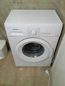 a white washer and dryer in a bathroom at Gkionis Apartment in Kalamata