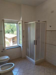 a bathroom with two toilets and a shower and a window at Agriturismo Il Mulino del Vescovo in Giano dellʼUmbria