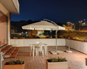 a patio with a table and chairs and an umbrella at Appartamento Tuttiventi in Campiglia Marittima