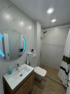 a white bathroom with a sink and a mirror at TWINS Apartments in Bregvija +35 photos