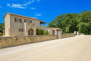 a house with a stone wall next to a road at Villa Catarina by IstriaLux in Kringa