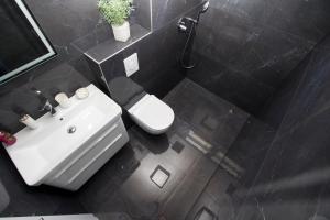 une salle de bain avec un lavabo blanc et des toilettes dans l'établissement Top5, à Baška Voda 25 autres photos