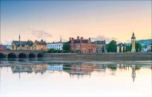 a city with a river and a bridge and buildings at Highgow House in Barnstaple