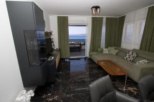 a living room with a couch and a flat screen tv at Top5 in Baška Voda