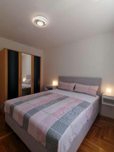 a bedroom with a large bed and two lamps at Apartment Cindy in Lovran