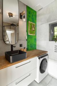 a bathroom with a sink and a washing machine at Okno na Beskidy in Maków Podhalański