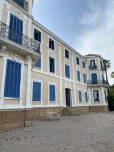 a large building with blue windows and chairs at Studio vue mer à Tamaris in La Seyne-sur-Mer
