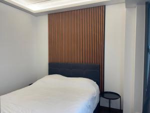a bedroom with a white bed and a wooden wall at Boutique Diamond Apartments in Antwerp