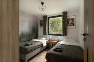 a bedroom with two beds and a window at Okno na Beskidy in Maków Podhalański