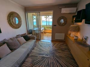 a living room with a couch and a view of the ocean at "Le palmier doré", cosy T3 à 3 minutes à pied des plages, parking et clim in Sanary-sur-Mer