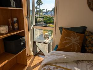 a bedroom with a bed and a window with a view at "Le palmier doré", cosy T3 à 3 minutes à pied des plages, parking et clim in Sanary-sur-Mer