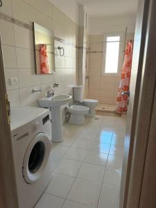 a bathroom with a toilet sink and a washing machine at Sea view appartment lungomare in Vlorë