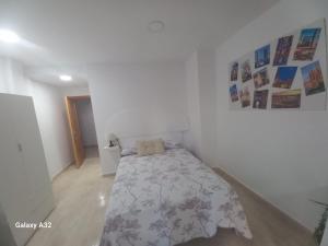 Un dormitorio con una cama en una habitación blanca. en Kilometro 0, en Alicante