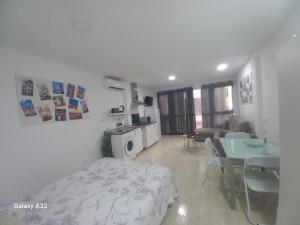 Una sala de estar con una cama y un comedor. en Kilometro 0, en Alicante