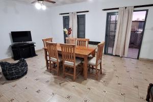 Un comedor con mesa y sillas de madera. en Alquiler Temporario FLEJj, en Santo Tomé