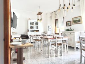 kuchnia i jadalnia ze stołami i krzesłami w obiekcie B&B Selvaggio Blu w mieście Baunei