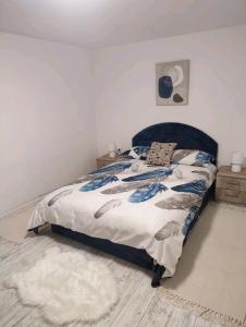 a bedroom with a bed with a blue head board at Gornji Milanovac Apartment in Gornji Milanovac