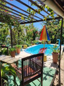 a swimming pool with a table and an umbrella at MANDALA DREAMS Pousada e Portal Holístico in Maceio