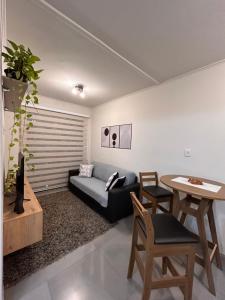 a living room with a couch and a table at Ap Novo Parque Anchieta - Top in Pelotas +13 photos