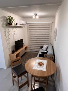 a small living room with a table and a bed at Ap Novo Parque Anchieta - Top in Pelotas