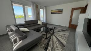 un soggiorno con un divano e un tavolo di Moderne Wohnung für bis zu 8 Personen mit großem Balkon a Niestetal