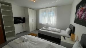 una piccola stanza con due letti e una televisione di Moderne Wohnung für bis zu 8 Personen mit großem Balkon a Niestetal