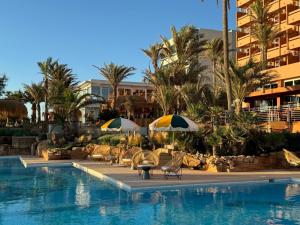 科洛尼亚圣霍尔迪Bikini Island & Mountain Hotel Es Trenc -Adults only-的度假村的游泳池，配有椅子和遮阳伞
