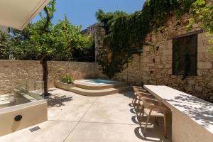 a patio with a table and chairs and a swimming pool at Lemon Garden Villa in Rethymno