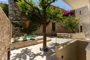 a courtyard with a tree in front of a building at Lemon Garden Villa in Rethymno