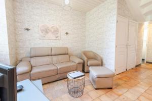 ein Wohnzimmer mit einer Couch und einem Sessel in der Unterkunft La petite maison sur la colline in Nazelles