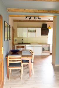 a kitchen with a wooden table and chairs in a room at Dzika Foka Wiosłowa 49 in Gdańsk +23 photos