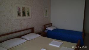 a small room with two beds and a table at El Doro Rooms in Dhërmi +26 photos